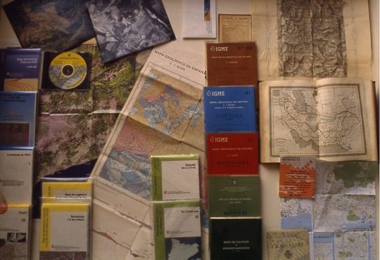 Fotografia 10. Materials cartogràfics. Diversos mapes impresos. Atles. Plànol de la ciutat. Mapa en CD-ROM. Fotografies aèries.